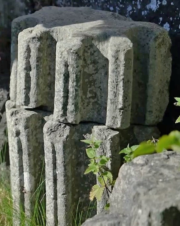 Färgfoto med två runda räfflade stenar som står på varandra.