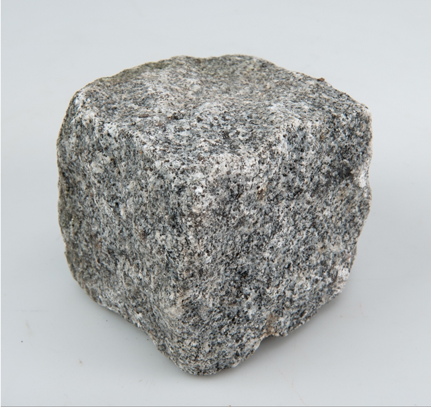 Fotografi. Grå granit formad som en kub. 