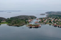 Foto. Bohus Malmön från ovan. Havet ligger stilla och det är disigt och grått i horisonten.